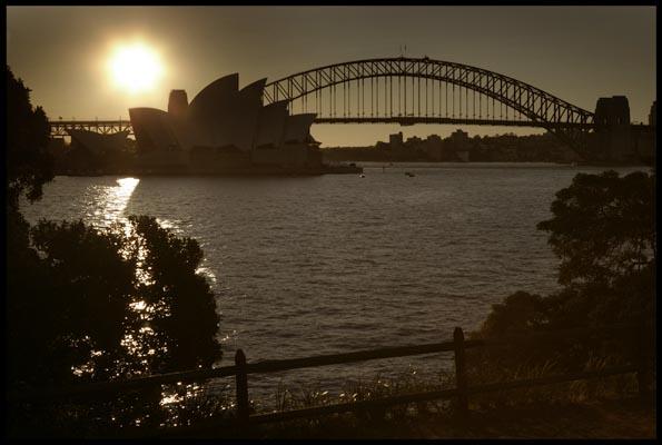 sunset behind the Opera House and the Harbour Bridge, as seen from Mrs Macquaries Point