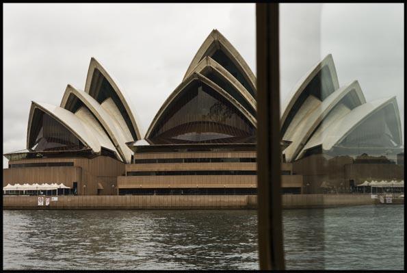 the Opera House from a ferry with a reflection in the ferry window