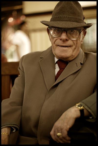 A portrait of a man with a hat and glasses visiting the QVB in Sydney