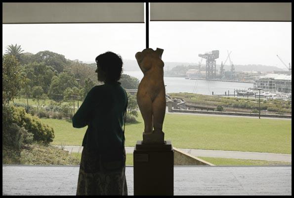 Art Gallery of NSW, a woman and a sculpture of a female torso before a view toward Garden Island