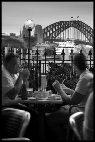 couple having dinner at café Rossini, Circular Quay at dusk with the Harbour Bridge