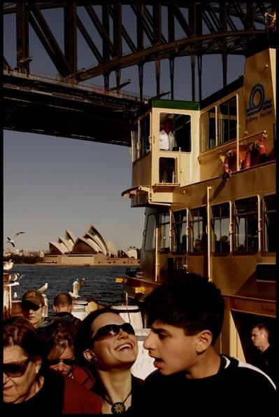 people dis-embarking at Milson Point Wharf, with the Opera House and detail of the Harbour Bridge in the background