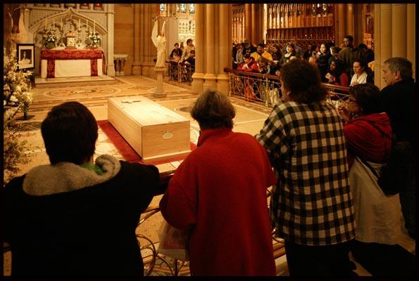 worshippers pray before a coffin of a saint in St Marys Cathedral at the Catholic World Youth Day 2008
